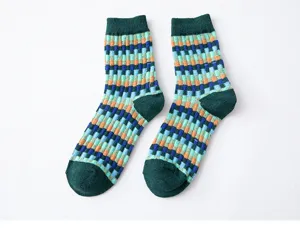 Gros plan de chaussettes mi-hautes chaudes pour femmes à motif de blocs géométriques colorés.