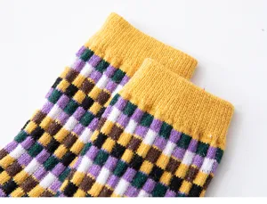 Gros plan détaillé de chaussettes à carreaux colorées avec poignets côtelés jaunes.