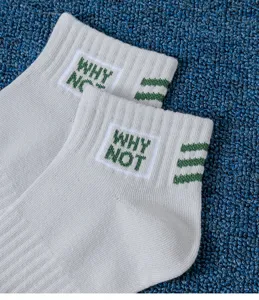 Detailed close-up view of mens casual short cotton socks featuring green why not embroidery.
