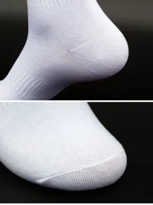 Close-up detail of white cotton athletic socks, showing the reinforced heel and toe.