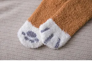 Detailed view of cozy coral fleece winter fuzzy sleep socks featuring cute cat paw prints.