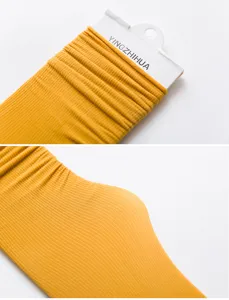 Detailed view of yellow velvet long slouch socks, showcasing ribbed cuffs and soft texture.