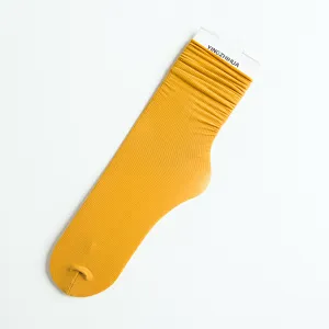 Solid yellow velvet long stacking socks with paper tag, flat lay product main view