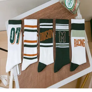 Detail view of trendy mid-calf cotton socks with sporty letters and stripe patterns.