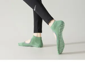 Close-up of green grip yoga socks with anti-slip silicone dots and open back design.