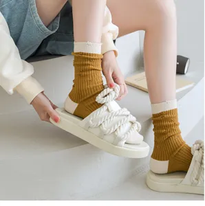 Stylish distressed mid-calf socks paired with trendy rope-strap sandals for a casual summer look.
