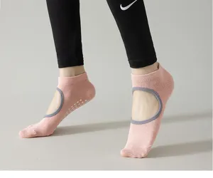 Non-slip yoga socks detail showing breathable pink fabric and silicone grip dots for fitness.