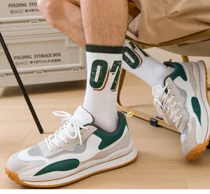 Detail shot of white men's crew socks with green number 07 pattern worn with casual sneakers.
