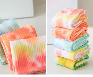 Detailed view of colorful tie-dye yoga socks, soft ribbed fabric, non-slip pilates sports socks.