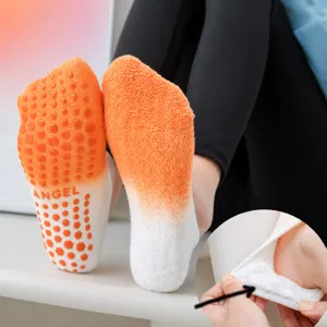 Gradient orange pilates grip socks with silicone dots and looped heel for yoga and fitness.