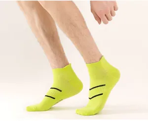 Detail view of neon yellow men athletic short socks with breathable black stripes for running.