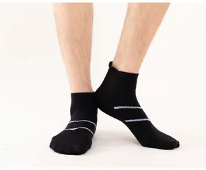 Detail view of black athletic short socks with double stripes, breathable knit fabric.
