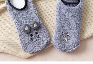 Close-up detail of soft coral fleece winter floor socks featuring cute 3D ears and embroidery.