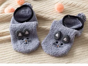 Close-up of grey fuzzy fleece winter floor socks featuring cute embroidered animal face details.