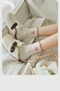 Cute fuzzy clogs and polka dot ruffle crew socks in cozy home setting detail shot.