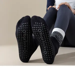 Vista dettagliata di calzini da yoga neri antiscivolo con pois per pilates e fitness.