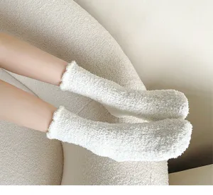 Close-up detail shot of ultra-soft fluffy white coral fleece socks, cozy indoor thermal wear.