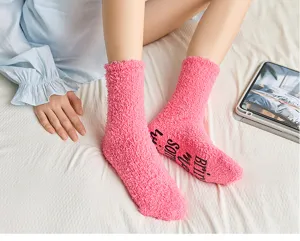 Cozy pink fuzzy coral fleece winter socks with non-slip sole and warm plush fabric.