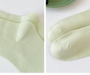 Detailed view of light green cotton mid-tube women socks, breathable and soft knit texture.
