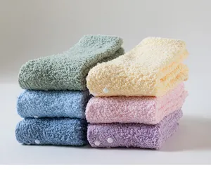 Close-up detail of soft fluffy coral fleece winter warm thermal socks with anti-slip dots.