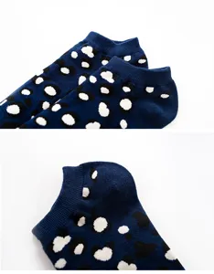 Detail view of dark blue short socks with abstract black and white dot pattern, cotton fabric.