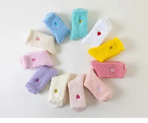 Détail en gros plan de chaussettes de sommeil en peluche colorées disposées en cercle.
