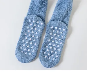 Thickened coral fleece socks detail showing anti-slip grip dots on sole for indoor home wear.