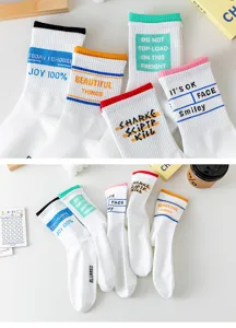 Vue détaillée de chaussettes en coton blanc avec des poignets côtelés colorés et des textes.