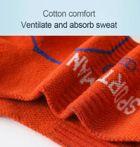 Close-up detail of breathable orange cotton sports socks with knitted text and fabric.