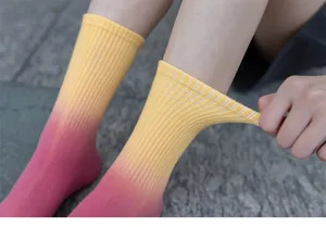 Detail shot of gradient mid-calf socks showing elastic cuff and vibrant color dye.