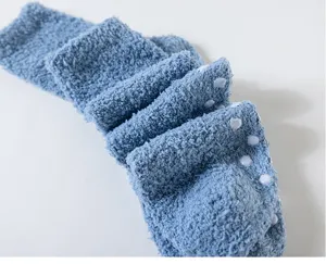 Close-up of thick fluffy coral fleece floor socks with anti-slip grip soles for winter warm wear.