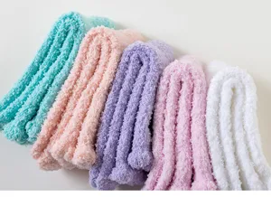 Gros plan détaillé de chaussettes de sommeil douces en polaire corail aux couleurs pastel.