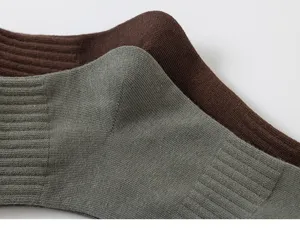 Primer plano detallado de calcetines de canalé lisos para hombre en verde oscuro y marrón.