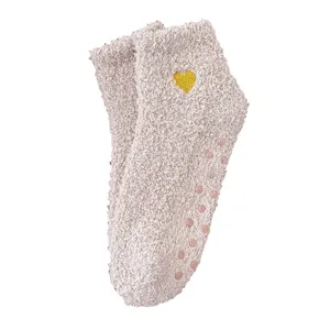 Cozy coral fleece women socks with cute heart embroidery and anti-slip dots for home wear.