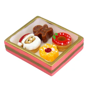 Close-up view of a miniature Christmas resin dessert tray featuring Santa and a gingerbread man.