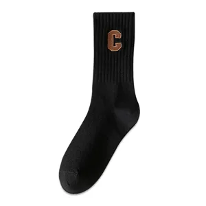 Black cotton crew socks for women featuring brown collegiate letter C embroidery patch.