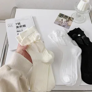 Vue rapprochée de chaussettes Lolita en tricot avec nœud et perle élégants.