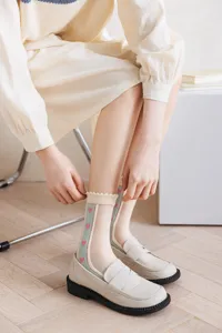 Close-up of sheer lace crew socks with sweet heart pattern and cute ruffle cuff.