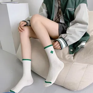 Green mid-calf socks for women featuring cute clover embroidery and striped ribbed cuffs.