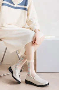 Close-up of sheer women's socks with cute pink hearts and blue stripes for daily sweet wear.