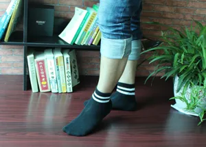 Calze sportive in cotone nero con due strisce bianche per giovani, comode e traspiranti.