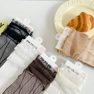 Détail de chaussettes mi-tubes en dentelle transparente, style Lolita mignon résille.