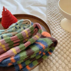 Cozy fluffy striped socks detail shot, cute colorblock design for winter warmth and retro style.
