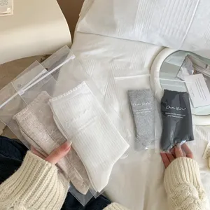 Vue de détail de chaussettes mi-tubes en dentelle style japonais en sachet transparent chambre.