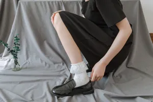 Detail shot of Japanese Lolita white lace ruffle mid-tube socks paired with black shoes.