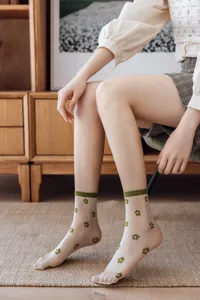 Vue détaillée de chaussettes transparentes pour femmes en soie avec imprimé floral.