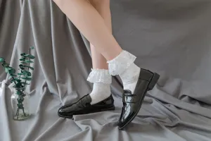 Detail shot of Japanese Lolita white lace ruffle socks and black patent leather loafers.