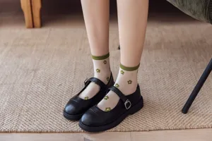 Gros plan de chaussettes transparentes avec motif floral vert et chaussures assorties.