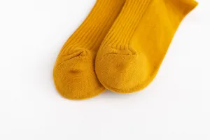 Close up view of mustard yellow ribbed cotton socks showing fine knit texture and toe detail.