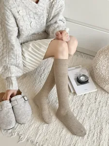 Close-up detail van gezellige geribbelde kniekousen in zacht beige gebreid voor de winter.